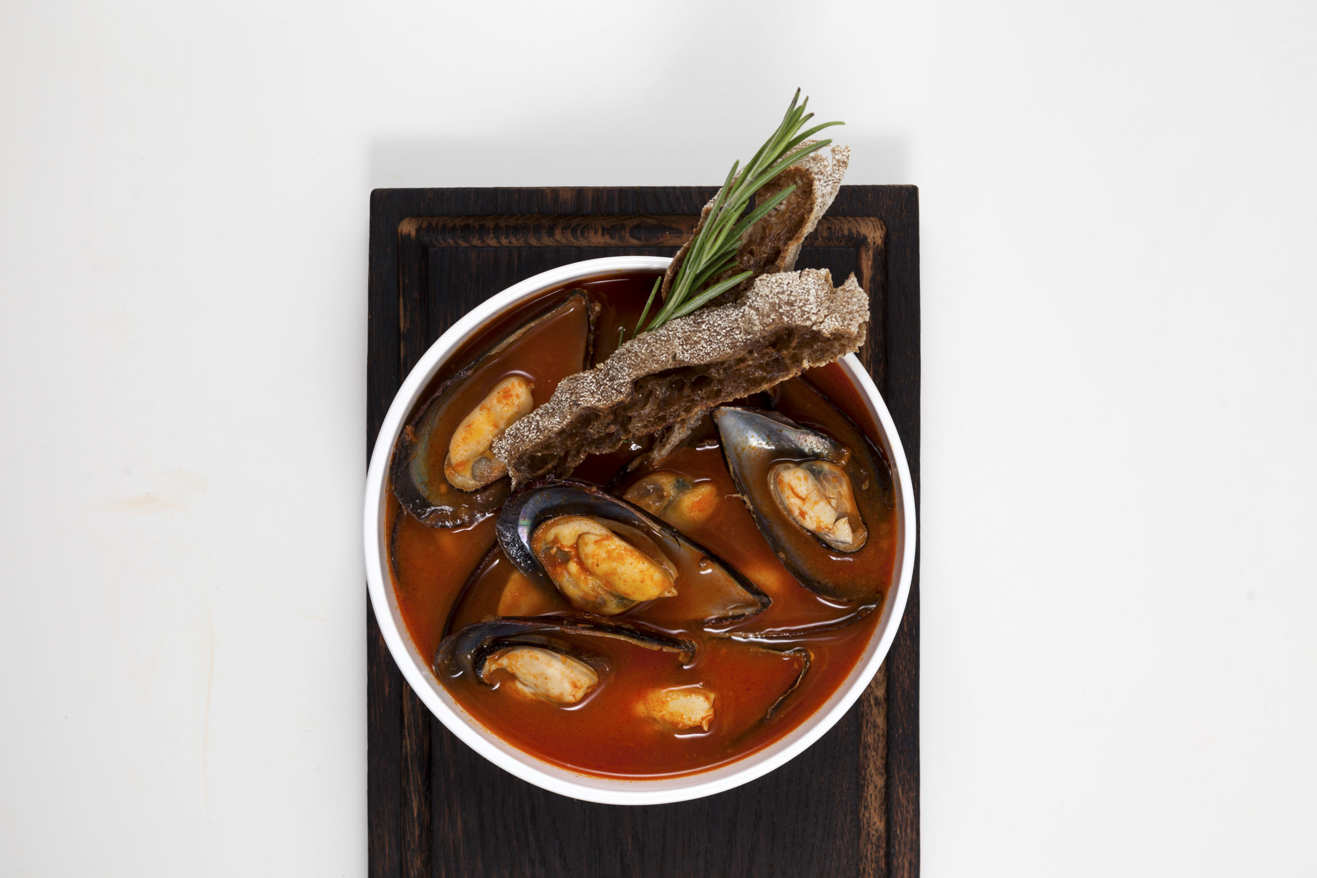 tomato soup with mussels served with rye croutons garnished with sprig rosemary scaled